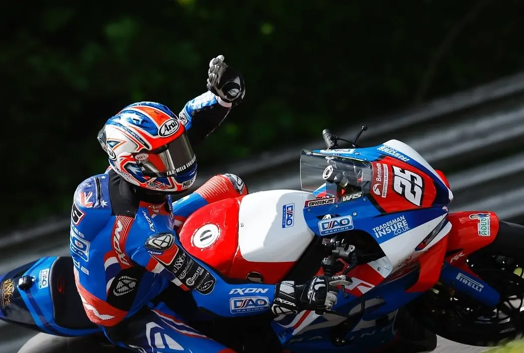 British Superbikes rider on a TradesmanInsure-sponsored bike waving to the crowd